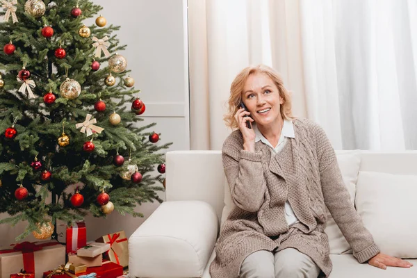 Frau telefoniert mit Smartphone in der Nähe des Weihnachtsbaums — Stockfoto