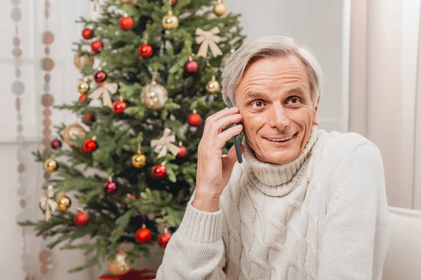 クリスマスにスマートフォンで話している男 — ストック写真