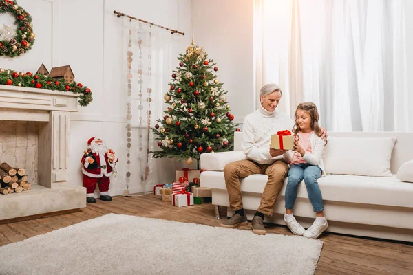 Grandfather presenting gift to granddaughter — Stock Photo, Image