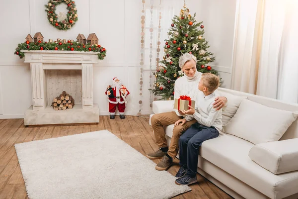 Avô apresentando presente de Natal ao neto — Fotografia de Stock