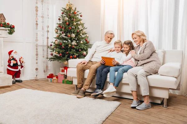 Grandparents and kids looking at tablet — Stock Photo, Image