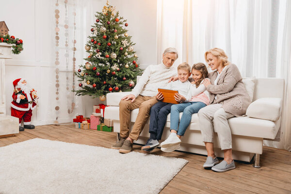 grandparents and kids looking at tablet