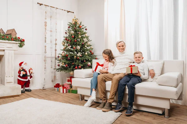 Grootvader en kinderen met kerstcadeaus — Stockfoto