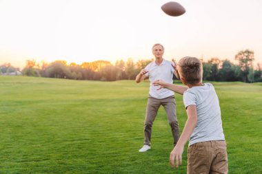 grandfather and grandson playing rugby clipart