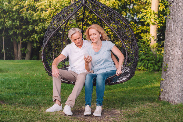 senior couple using smartphone together