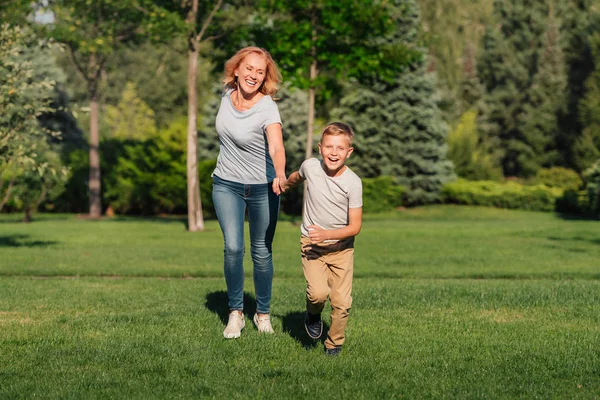 Familjen som körs på grön gräsmatta — Stockfoto