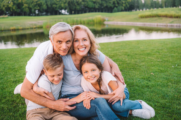 family resting on meadow