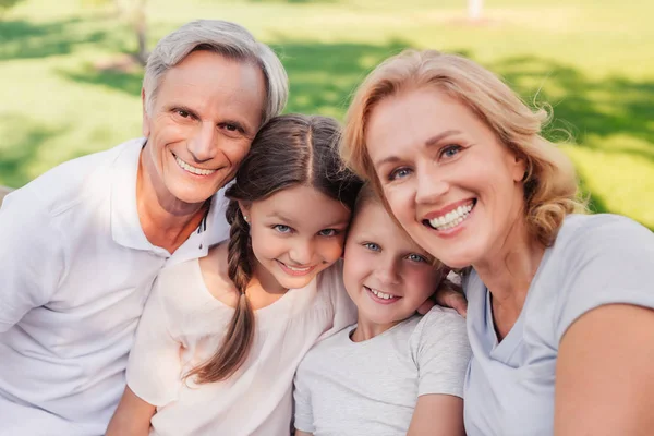 Birlikte parkta oturan aile — Stok fotoğraf