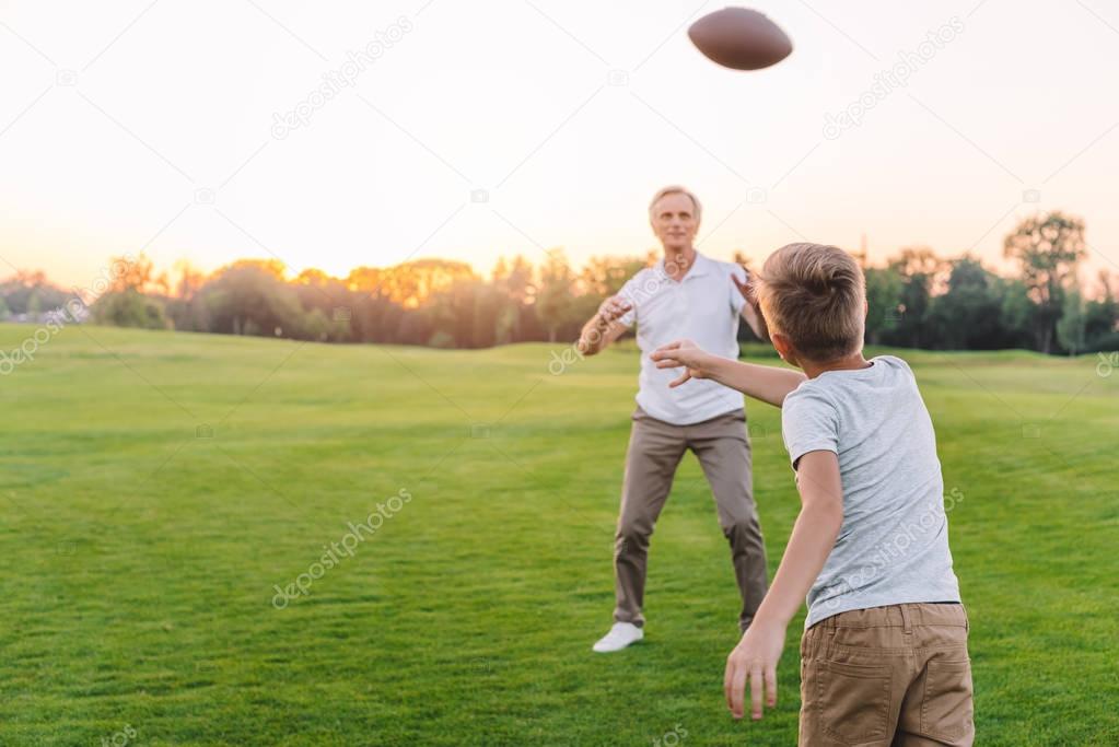 grandfather and grandson playing rugby