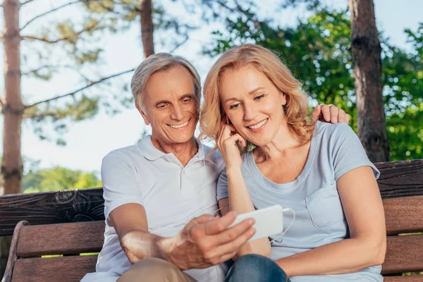 Пожилая пара использует смартфон вместе — стоковое фото