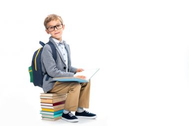 okul çocuğu sittting yığında kitap ve okuma