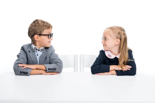Rozkošný žáci sedí u stolu — Stock fotografie
