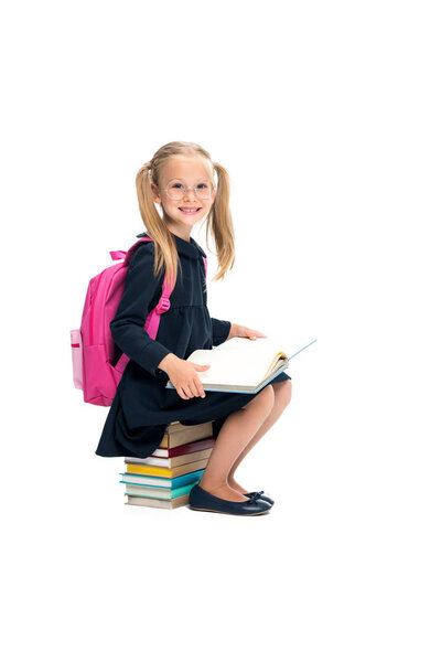 schoolgirl sitting on stack of books