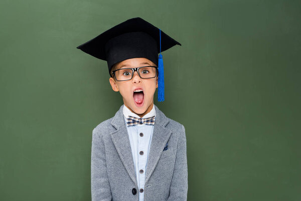 shocked schoolboy in graduation hat
