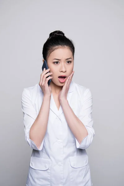 Surprised nurse talking on phone — Stock Photo, Image