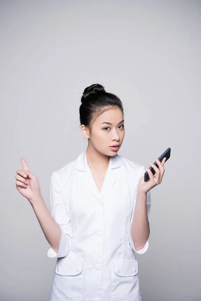 Young nurse holding smartphone