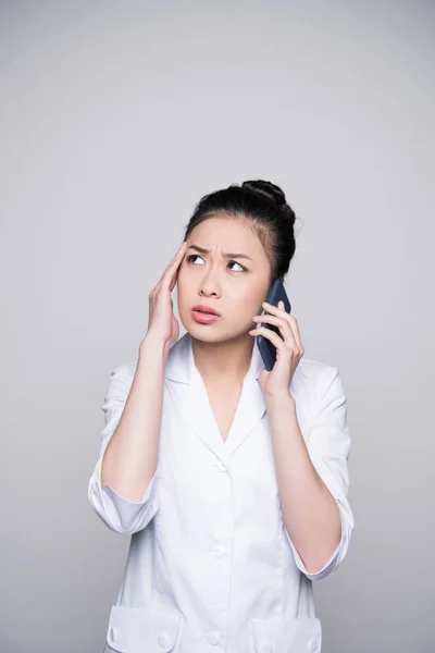 Concerned nurse talking on phone — Stock Photo, Image