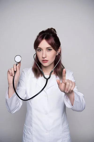 Doctora joven sosteniendo estetoscopio — Foto de stock gratuita