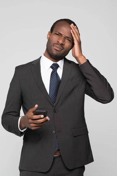 Businessman touching his head and squinting — Stock Photo, Image