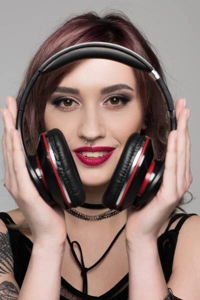 Mujer joven sosteniendo grandes auriculares — Foto de Stock