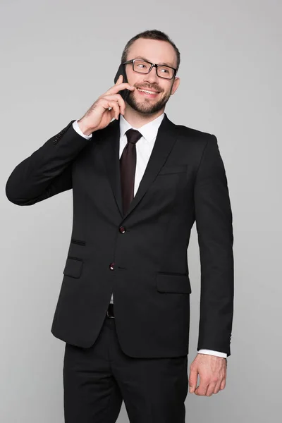 Улыбающийся молодой бизнесмен разговаривает по телефону — стоковое фото