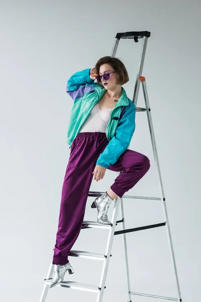 Mujer elegante apoyada en la escalera — Foto de Stock