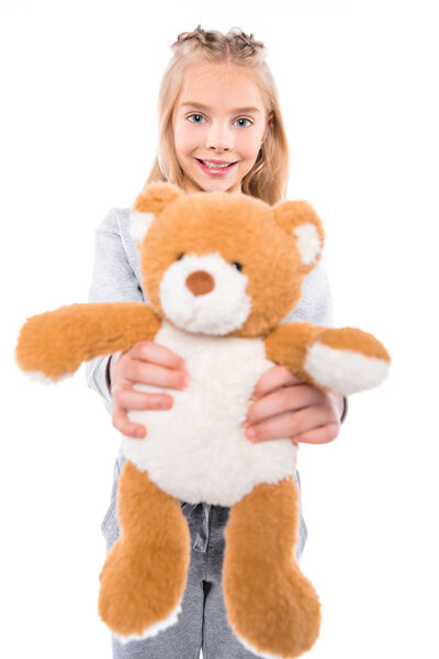 child holding teddy bear