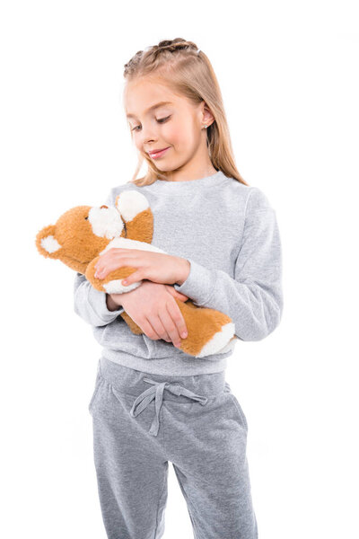 child carrying teddy bear