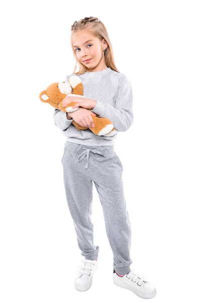 child carrying teddy bear