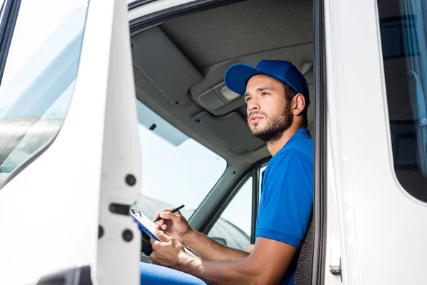 Delivery man filling in documents — Stock Photo, Image