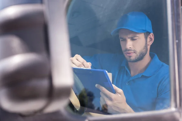 Delivery man filling in documents — Stock Photo, Image