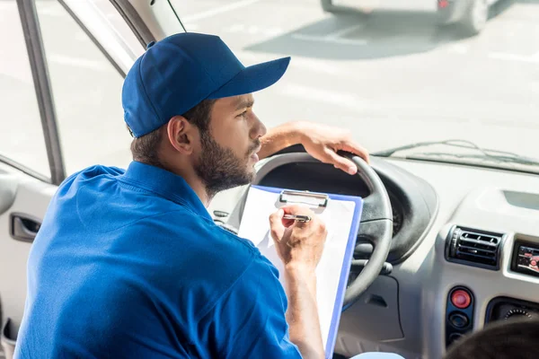 Entrega hombre escribiendo en portapapeles — Foto de Stock