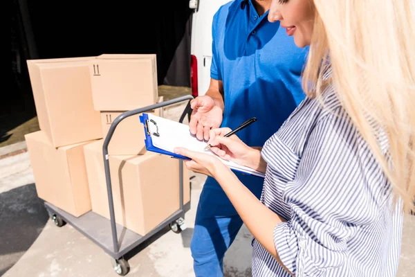 Woman signing delivery document — Stock Photo, Image