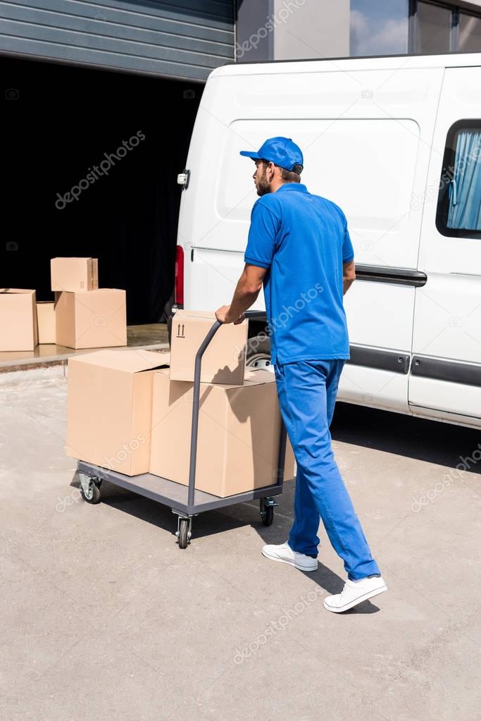 delivery man driving cart with boxes