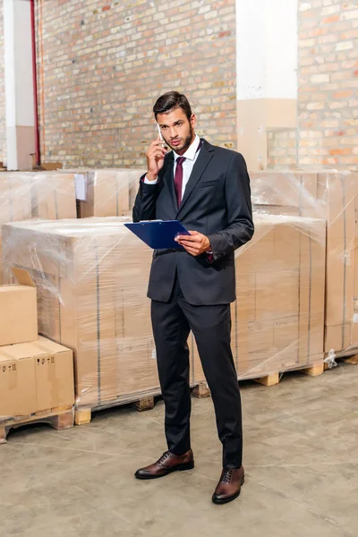 Businessman talking by phone at warehouse — Stock Photo, Image