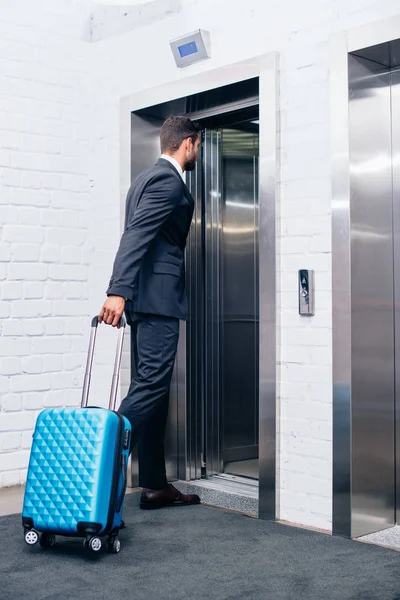 Бізнесмен з валізою, що входить в ліфт — стокове фото