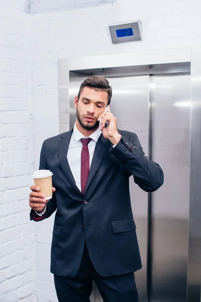 Бизнесмен разговаривает по телефону с кофе — стоковое фото