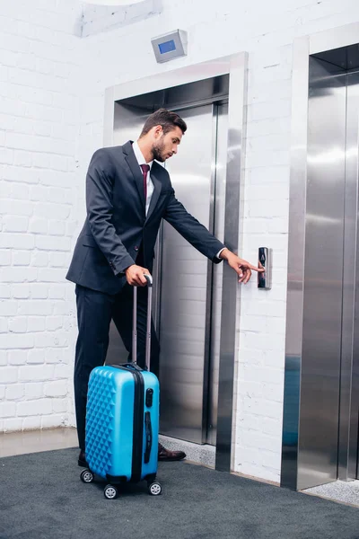 Homem de negócios com mala ao lado do elevador — Fotografia de Stock