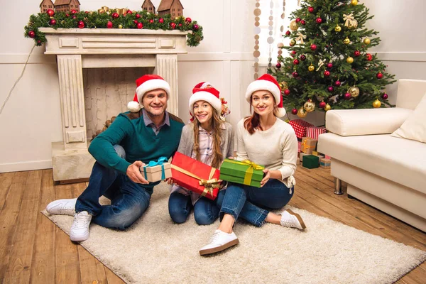 クリスマスの贈り物を持つ幸せな家族  — 無料ストックフォト