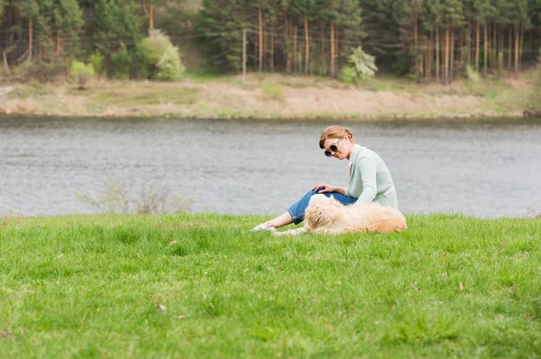 Женщина с собакой на траве — стоковое фото