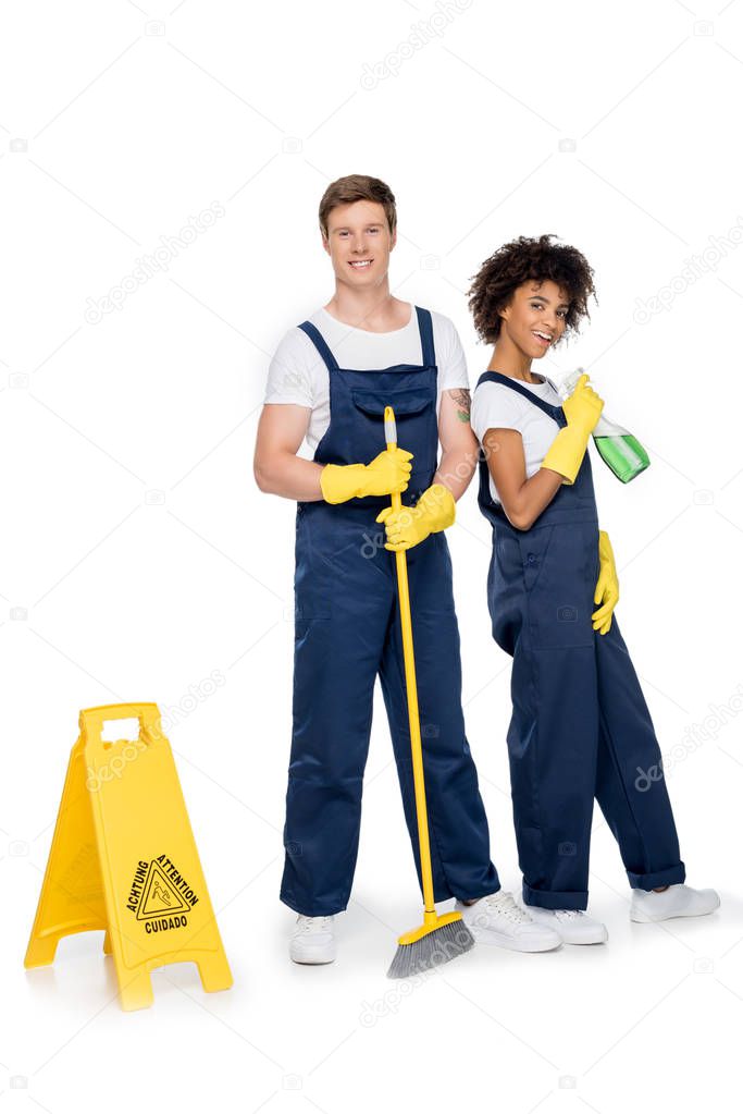 smiling multiethnic cleaners with cleaning supplies
