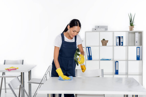 young cleaner wiping table