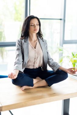 businesswoman meditating at workplace clipart