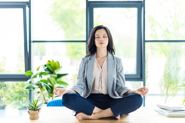 businesswoman meditating at workplace