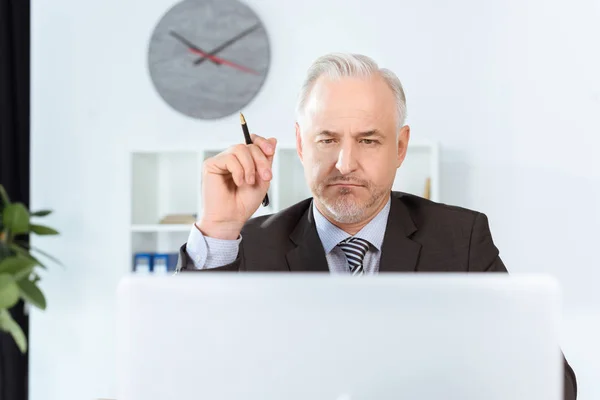 Geschäftsmann schaut auf Laptop — Stockfoto