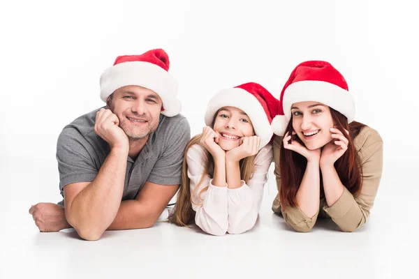 Lächelnde Familie mit Weihnachtsmann-Hüten — Stockfoto
