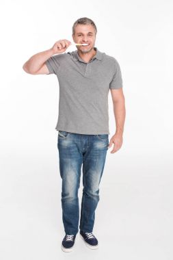 Adam dişlerini fırçalıyor. 