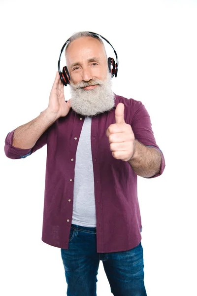 Старший чоловік слухає музику з навушниками — стокове фото