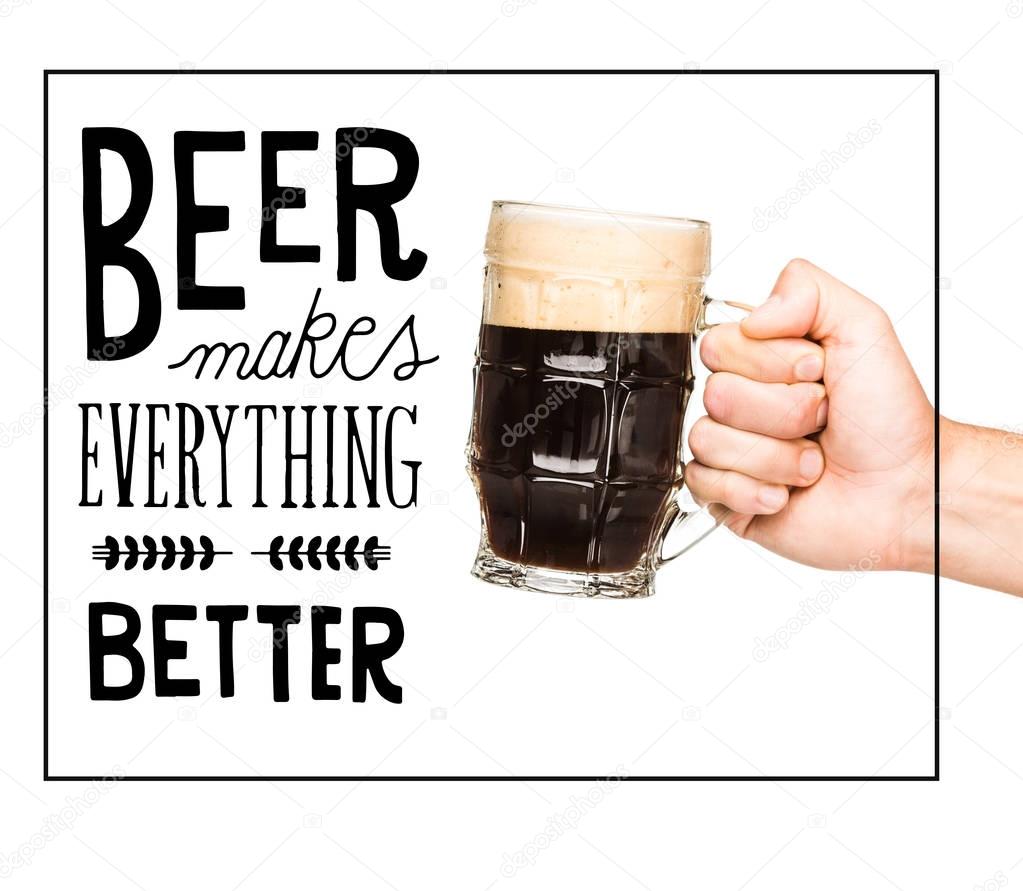 Cropped view of person holding glass of dark beer