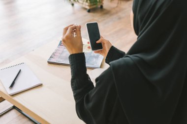 muslim woman using smartphone clipart